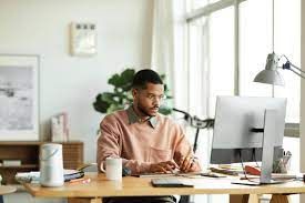 a man sitting at a desk looking at a computer